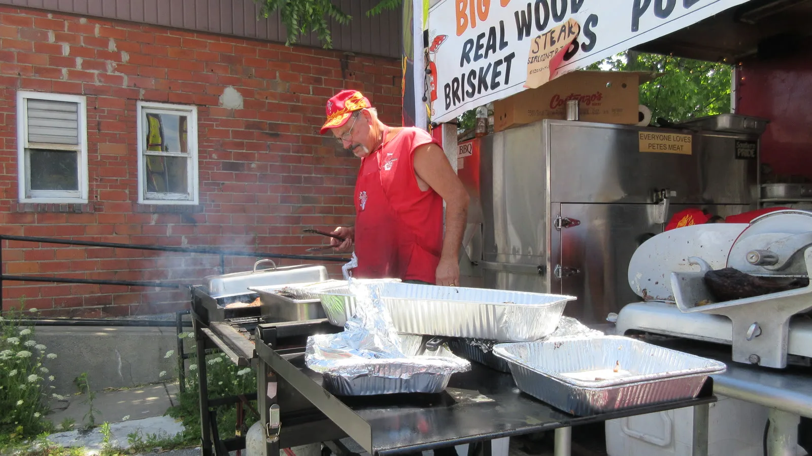 Pit Master Pete at the grill beside the Big Belly BBQ truck